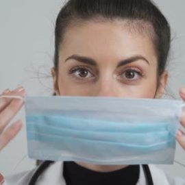 Videohive Young Female Doctor Puts Face Mask on Mouth and Nose. Protective Measures Against COVID-19, Close (Stock Footage) Free Download